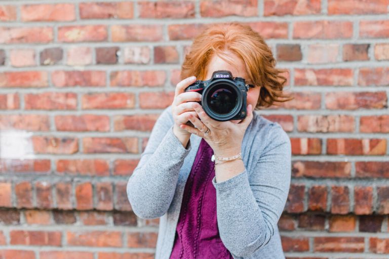 woman looking through a Nikon camera